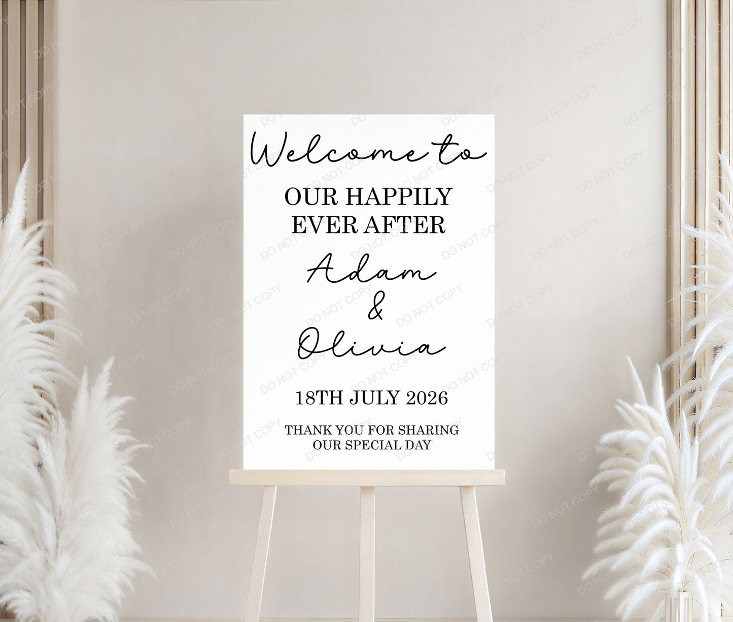 Wedding welcome sign on a stand with decorative plants against a neutral wall.