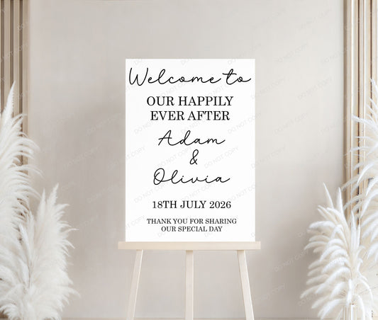 Wedding welcome sign on a stand with decorative plants against a neutral wall.